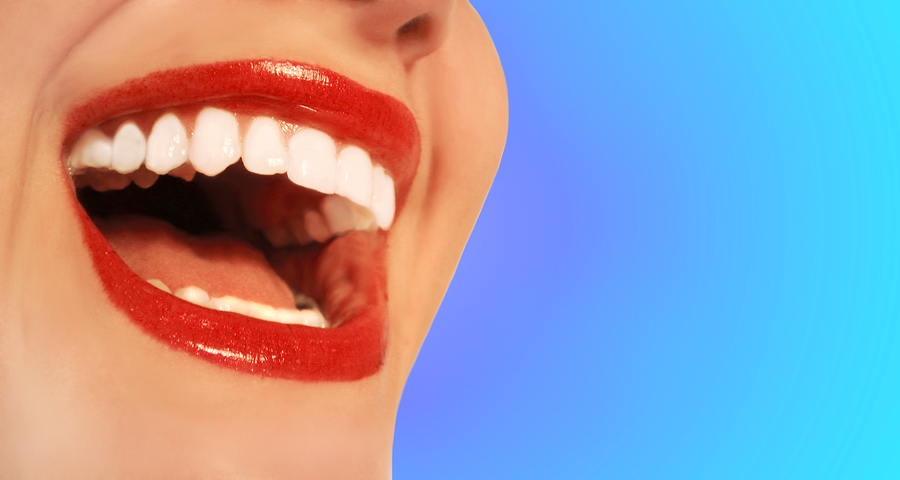 woman smiling with beautiful white teeth on a blue background